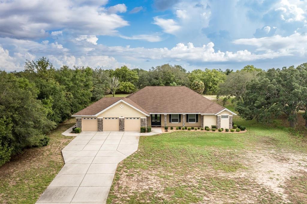 An aerial view of a single-story house with a three-car garage and a concrete driveway — 343 ROYAL PALM WAY, SPRING HILL, FL