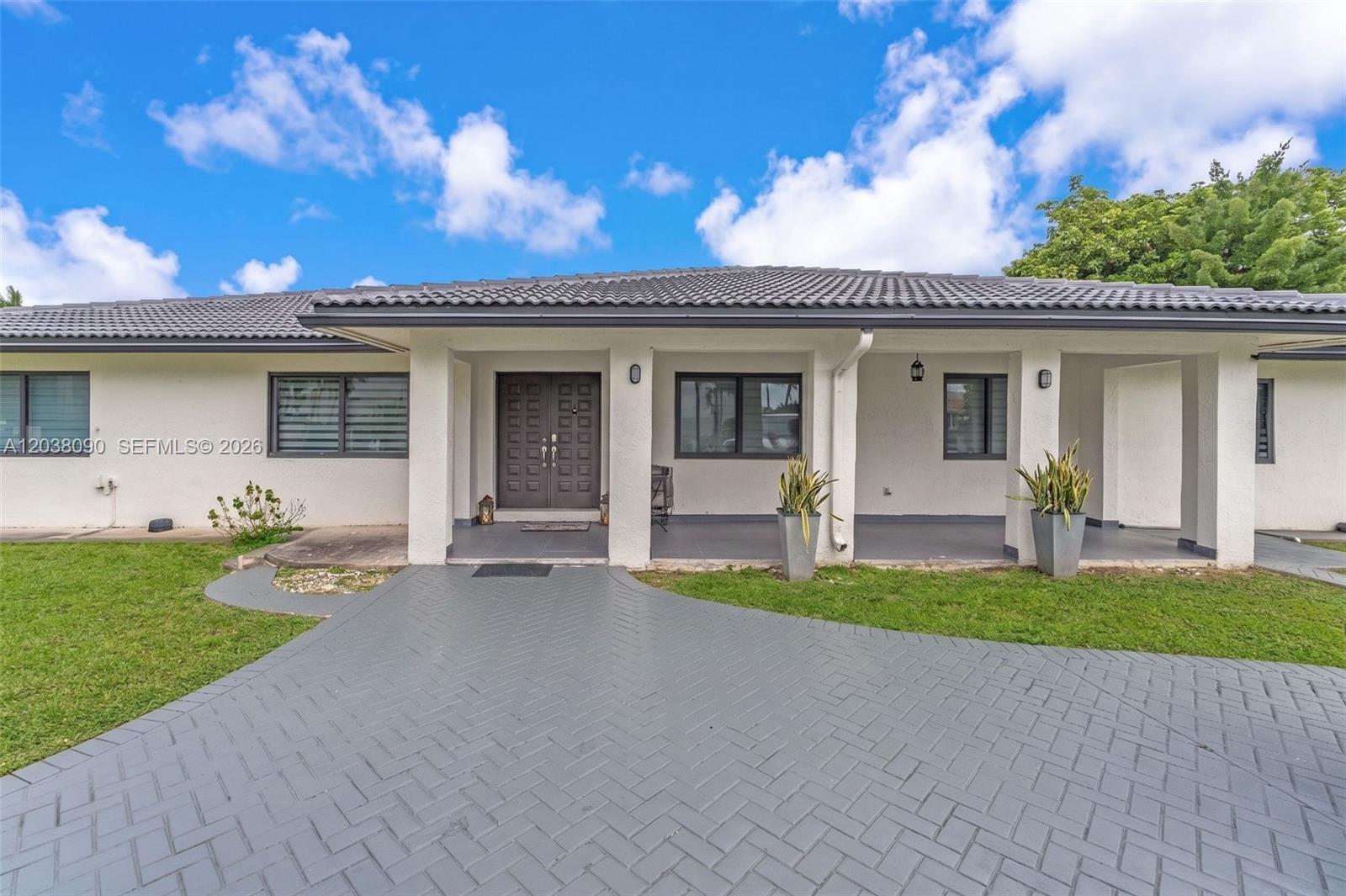 The exterior of a single-story house features a gray tiled roof and a paved driveway — 551 SW 127th Ave, Miami FL 33184, MIAMI, FL