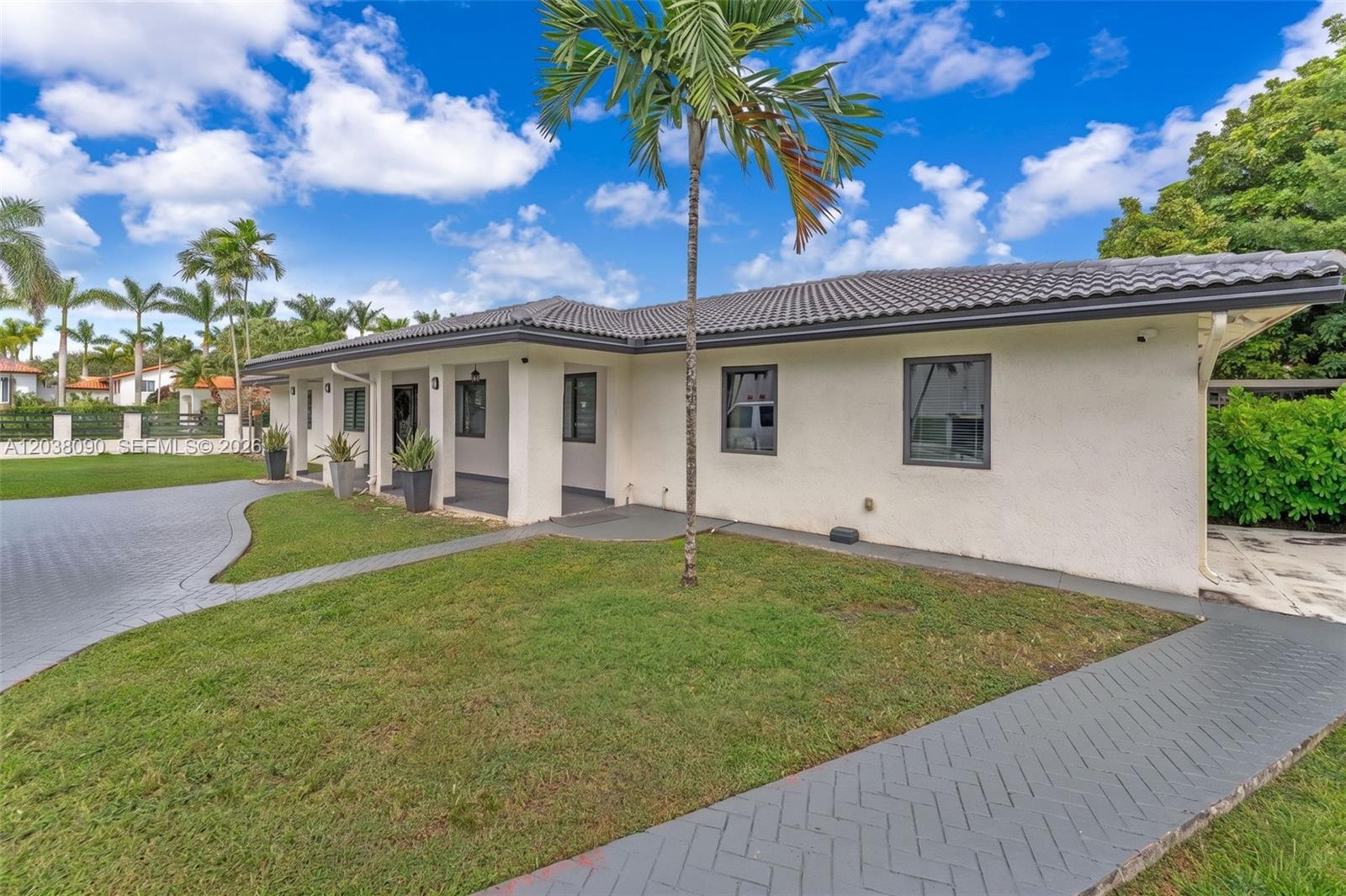 A single-story house with a white stucco facade, gray roof, and a paved walkway — 551 SW 127th Ave, Miami FL 33184, MIAMI, FL