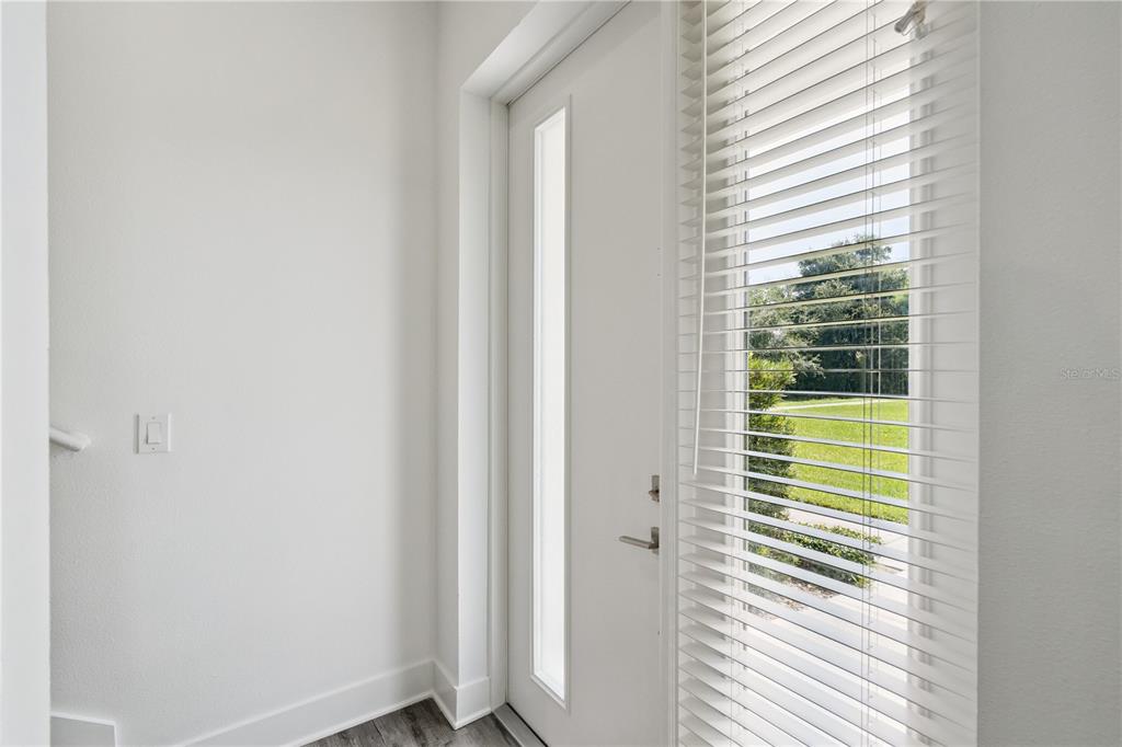 A bright entryway features a white door with a vertical window and white horizontal blinds — 1841 HOUSTON STREET, KISSIMMEE, FL