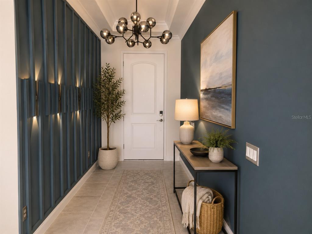 A modern entryway features a blue paneled wall, a console table, and a globe chandelier — 13207 AYLESBURY STREET, ORLANDO, FL