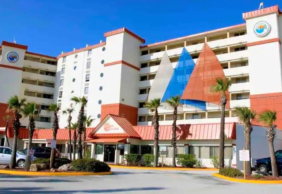 A multi-story hotel building with white walls, orange accents, and decorative sail-shaped structures on the facade — 701 S ATLANTIC AVENUE UNIT 520, DAYTONA BEACH, FL