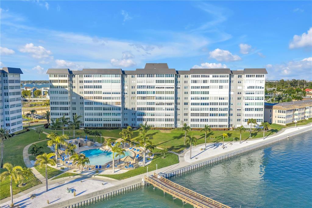 An aerial view shows a large waterfront apartment complex with a pool and a pier — 5108 BRITTANY DRIVE S UNIT 405, ST PETERSBURG, FL