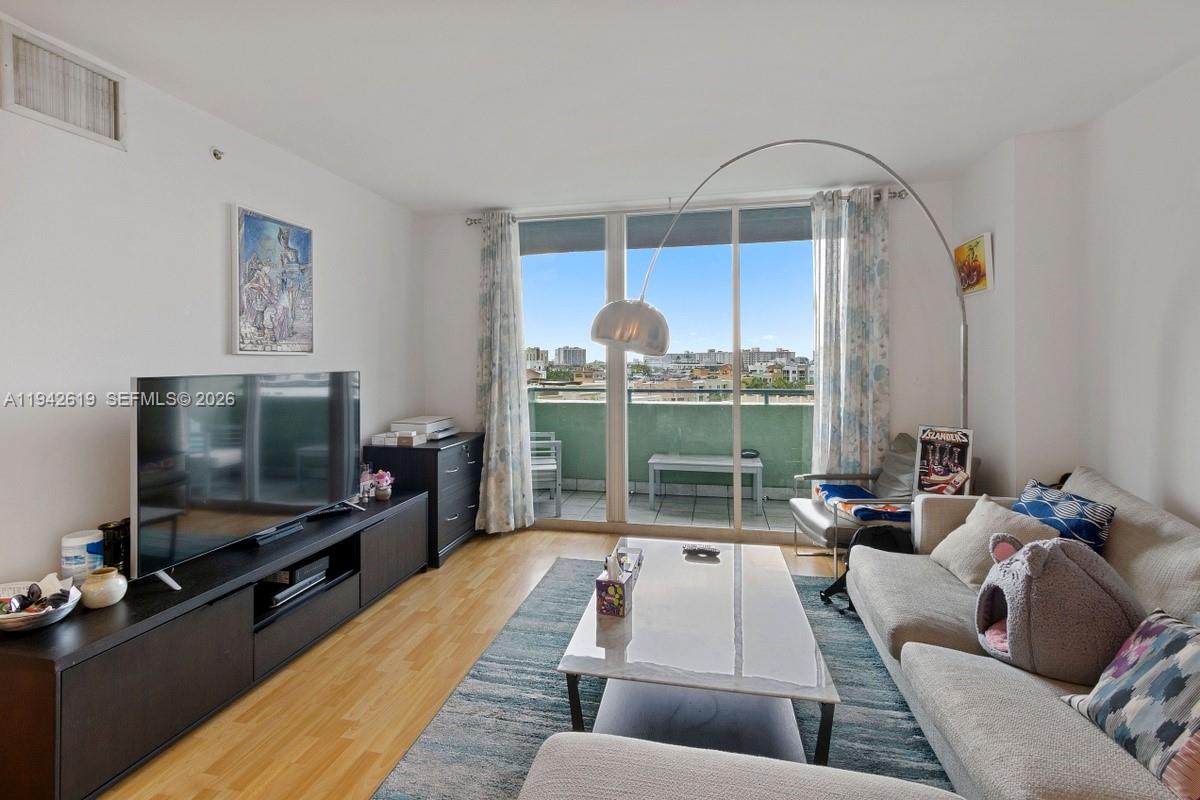 A living room features a sectional sofa, a marble coffee table, and a large television — 90 Alton Rd # 807, Miami Beach FL 33139, MIAMI BEACH, FL