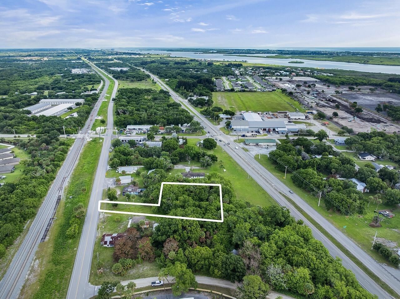 An aerial view shows a rectangular plot of land outlined in white among trees — VERO BEACH, FL