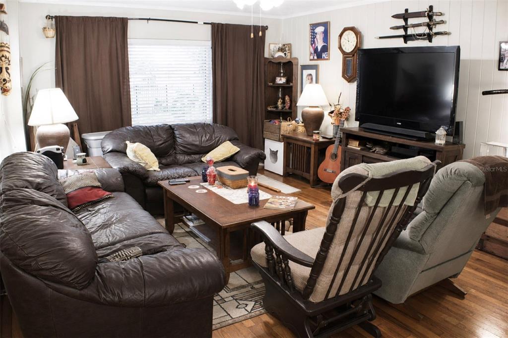 A living room features brown leather sofas, a wooden coffee table, and a television console — 1405 28TH STREET NW, WINTER HAVEN, FL