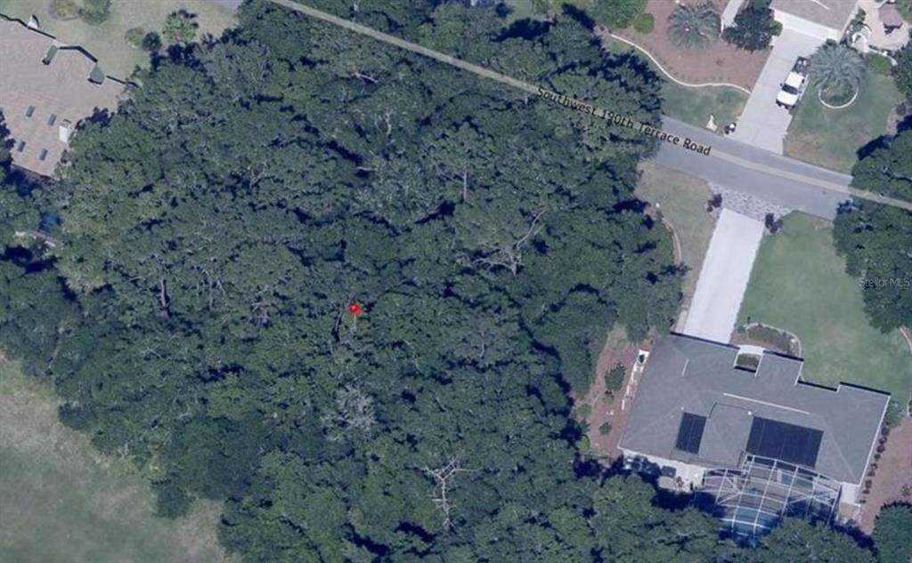 An aerial view shows a wooded residential lot next to a house and road — SW 190TH TERRACE, DUNNELLON, FL