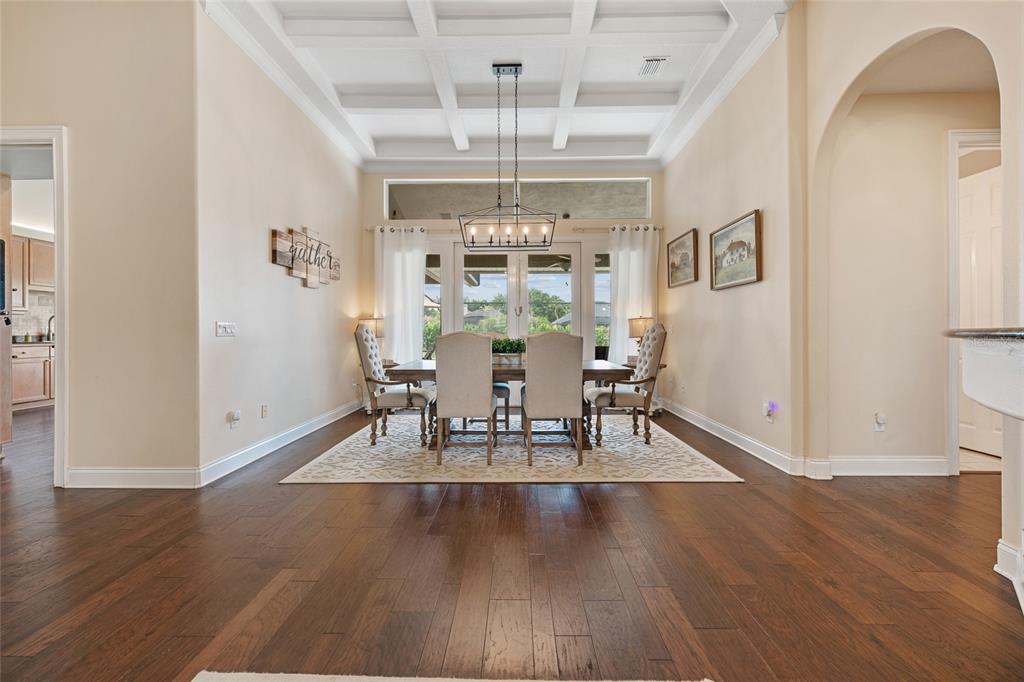 A dining room features a coffered ceiling, hardwood floors, and a table with six chairs — 8612 OLDBRIDGE LANE, ORLANDO, FL