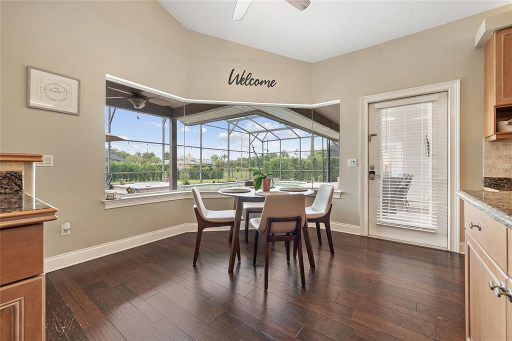 A dining nook with dark wood floors, a bay window, and a glass door — 8612 OLDBRIDGE LANE, ORLANDO, FL