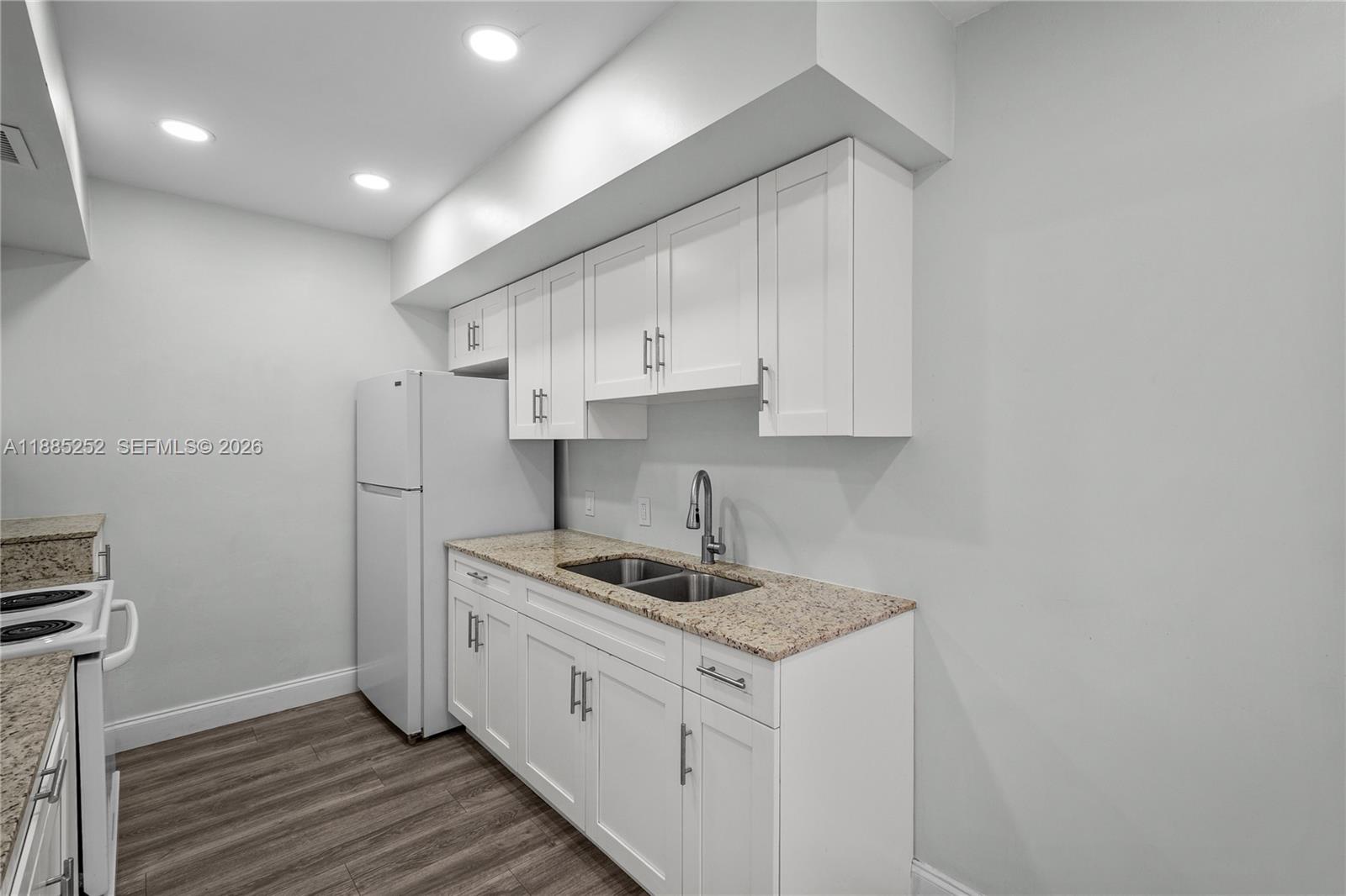 A kitchen features white cabinets, granite countertops, a stainless steel sink, and a white refrigerator — 245 NE 191st St # 3014, Miami FL 33179, MIAMI, FL