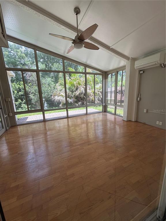 A sunroom with wood-look flooring, a ceiling fan, and large windows overlooking a backyard — 5554 LIGUSTRUM LOOP, OVIEDO, FL