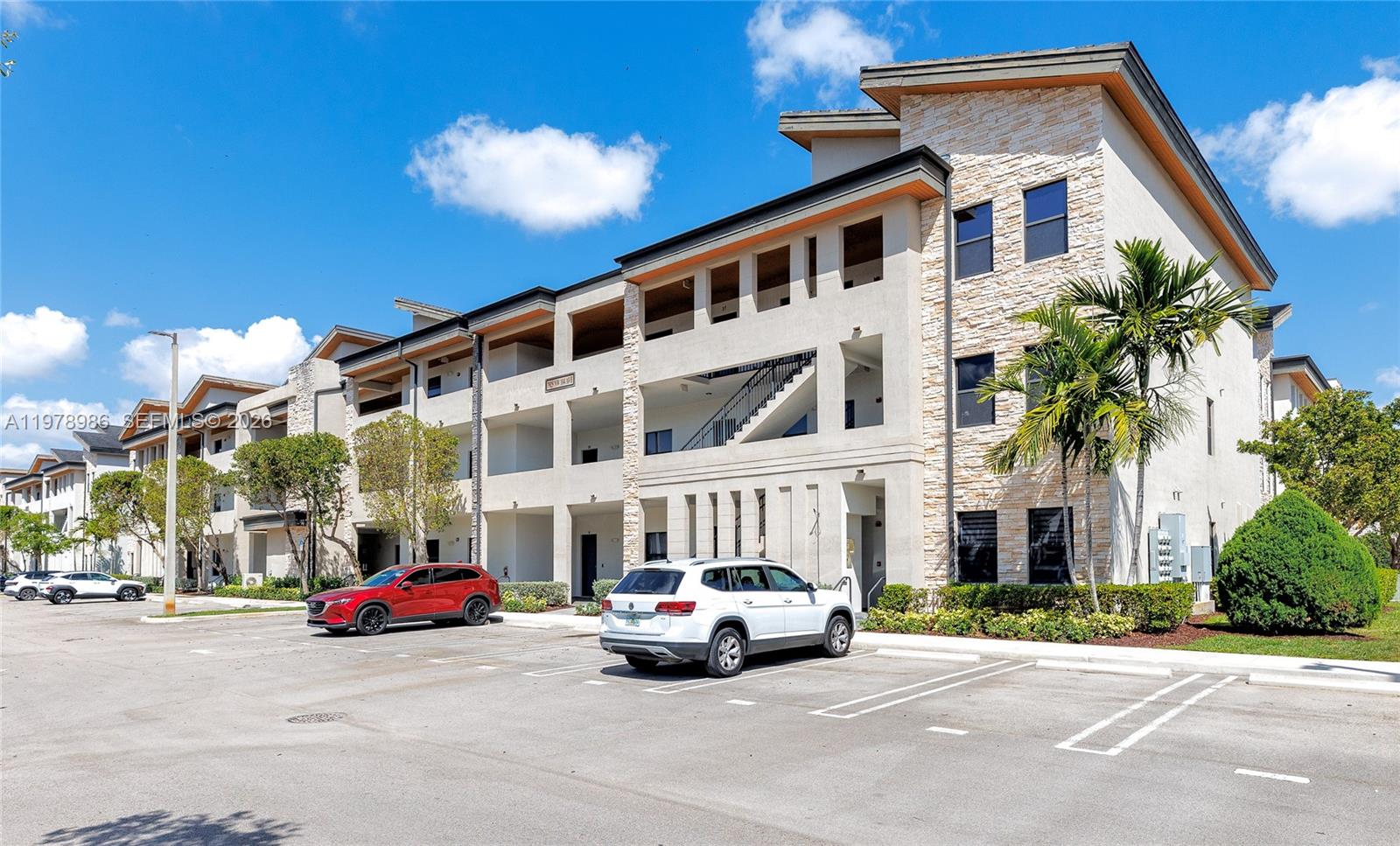A three-story apartment building with stone accents and a parking lot in front — 7925 NW 104th Ave # 28, Doral FL 33178, DORAL, FL