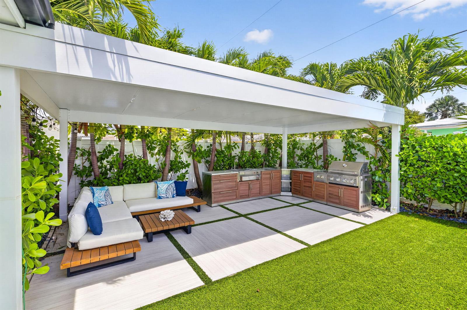 An outdoor patio features a covered kitchen area with a sectional sofa and artificial turf — 2917 NE 35th Court, Lighthouse Point FL 33064, LIGHTHOUSE POINT, FL