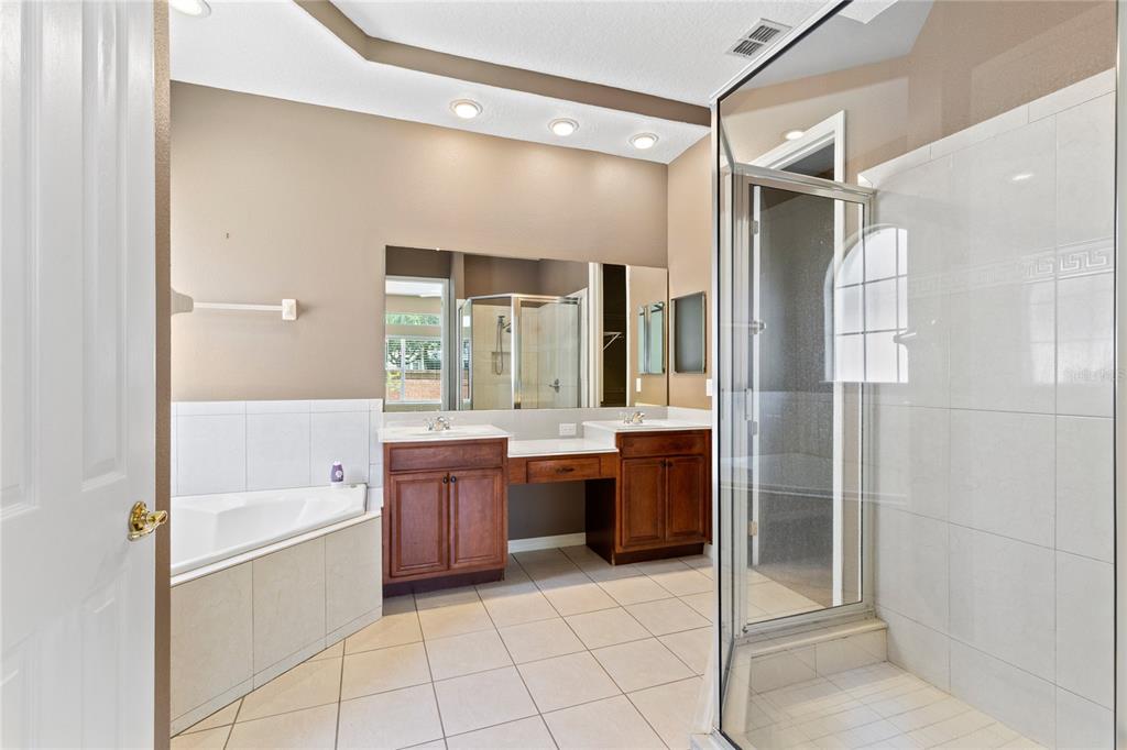 A bathroom features a double vanity, a corner soaking tub, and a glass-enclosed shower — 16407 BRISTOL LAKE CIRCLE, ORLANDO, FL