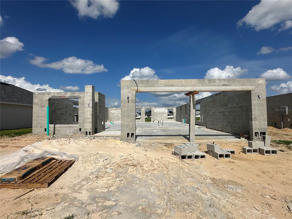The exterior of a house under construction shows concrete block walls and a concrete slab foundation — 12543 NE 48TH TERRACE, OXFORD, FL