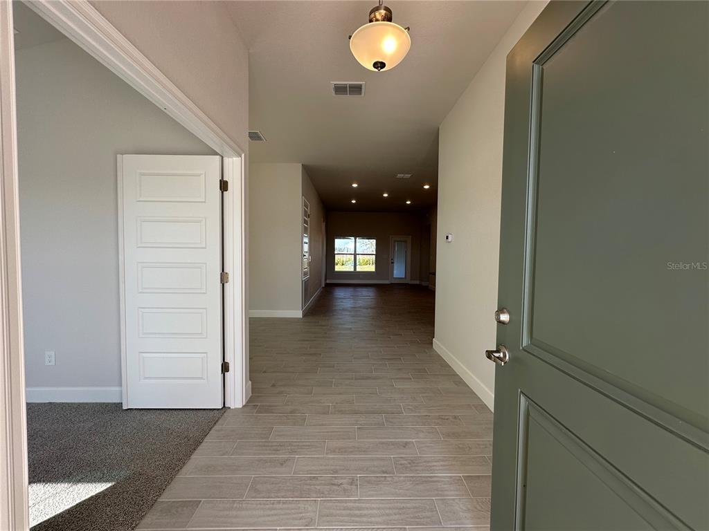 A view from an entryway looking into a home with tile flooring and recessed lighting — 12543 NE 48TH TERRACE, OXFORD, FL