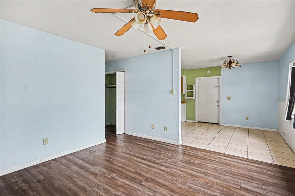 A room with light blue walls, wood-look flooring, a ceiling fan, and an adjacent tiled area — 520 S ORANGE AVENUE, FORT MEADE, FL