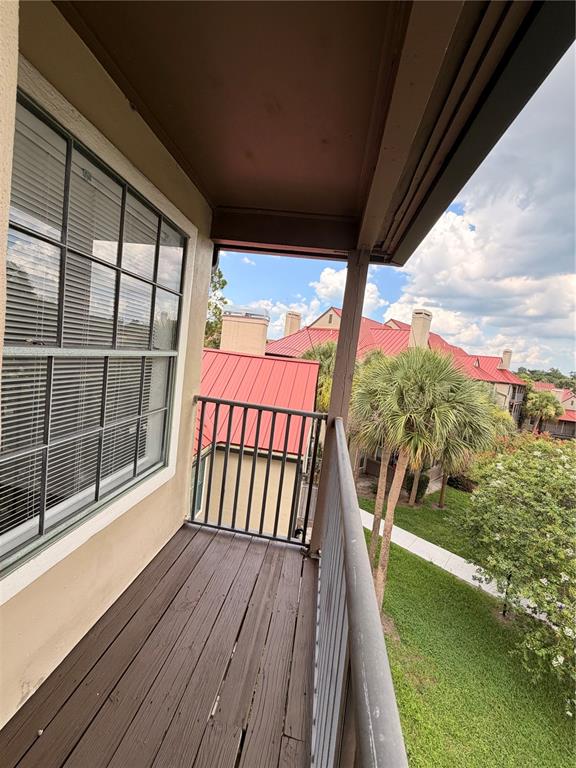 A balcony with dark wood flooring, a metal railing, and a view of neighboring buildings — 232 AFTON SQUARE UNIT 309, ALTAMONTE SPRINGS, FL