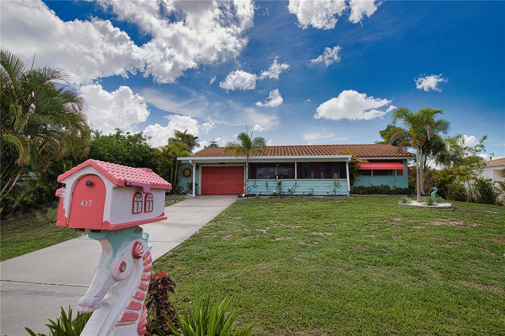 A single-story house with a turquoise exterior, red roof, and a decorative seahorse-shaped mailbox — 457 W TARPON BOULEVARD NW, PORT CHARLOTTE, FL