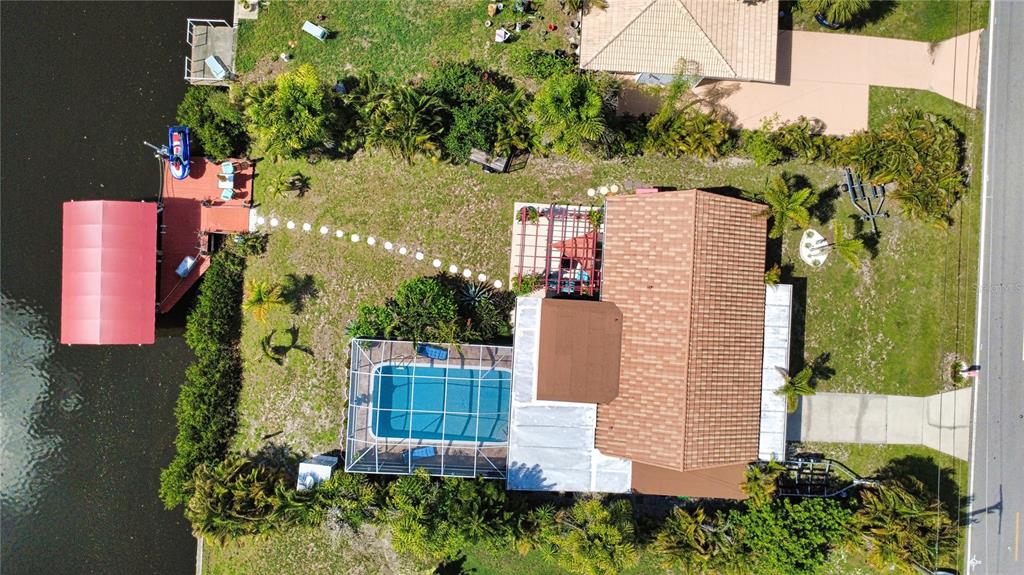 An aerial view shows a house with a pool, a dock, and a boat lift — 457 W TARPON BOULEVARD NW, PORT CHARLOTTE, FL