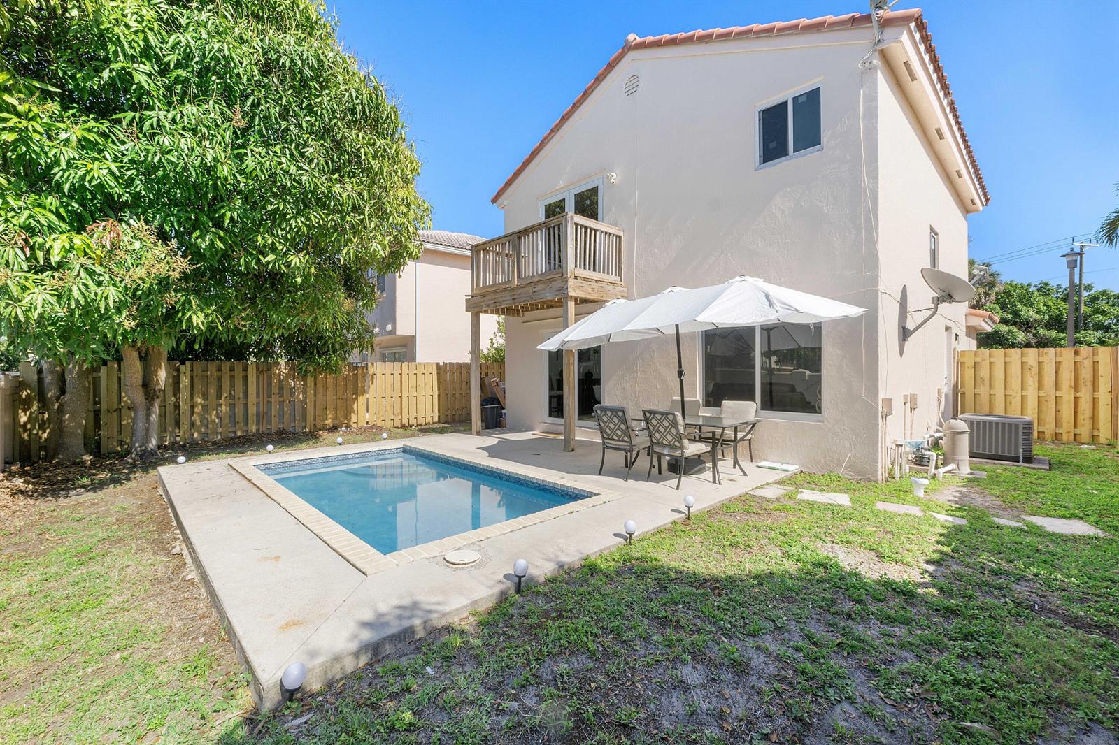 A two-story house with a backyard pool, patio furniture, and a wooden balcony — 6363 Seagrape Circle, Margate FL 33063, MARGATE, FL