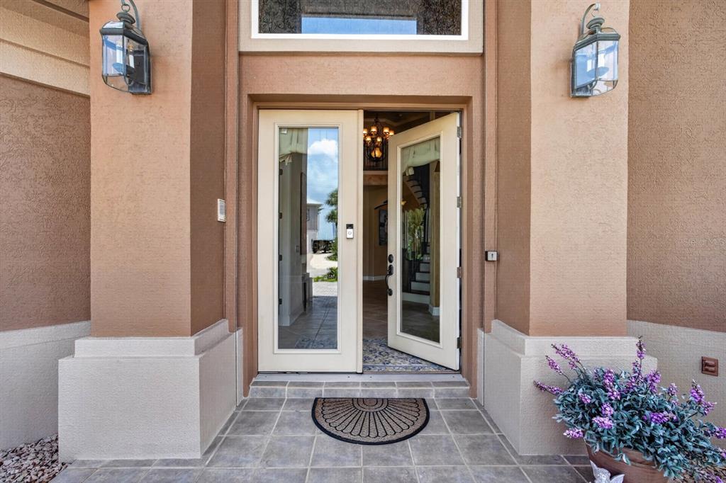 A front entryway features double glass doors, two wall-mounted lanterns, and a potted plant — 621 RIVER VIEW ROAD, FLAGLER BEACH, FL
