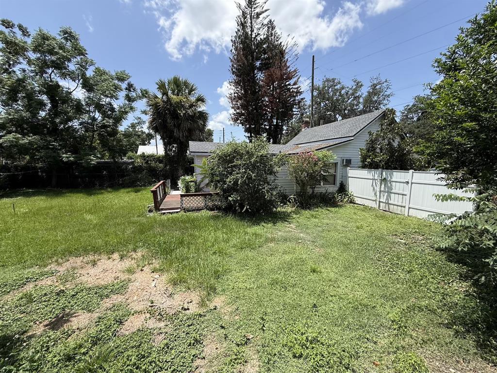 A backyard view of a white house with a wooden deck and a white fence — 1101 N HAMPTON AVENUE, ORLANDO, FL