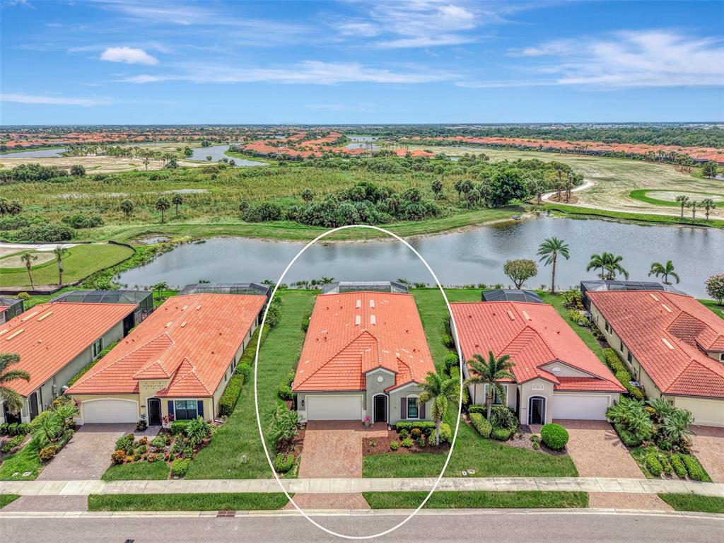 An aerial view of a single-story house with a red tile roof and a pool — 24268 GALLBERRY DRIVE, VENICE, FL