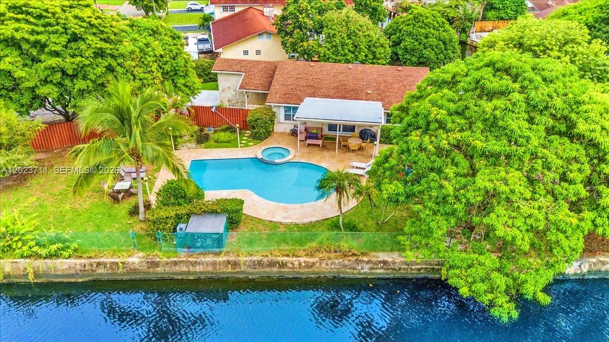 An aerial view shows a house with a swimming pool, patio, and canal-side backyard — 2650 Scott St, Hollywood FL 33020, HOLLYWOOD, FL
