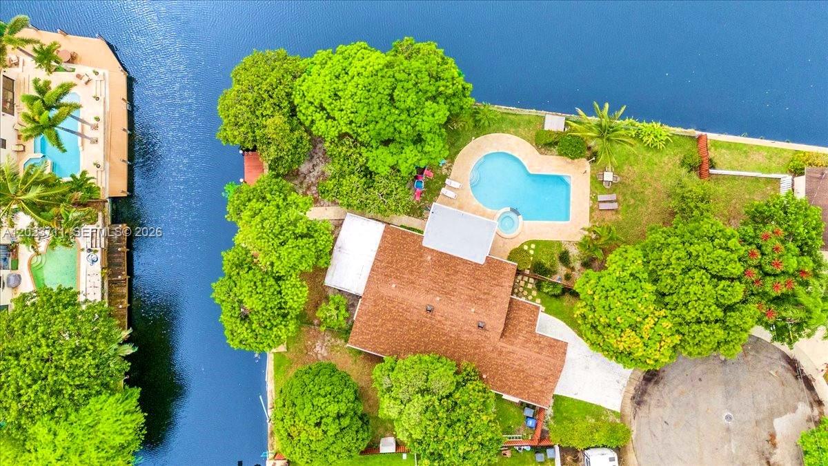 An aerial view shows a house with a pool and trees beside a canal — 2650 Scott St, Hollywood FL 33020, HOLLYWOOD, FL