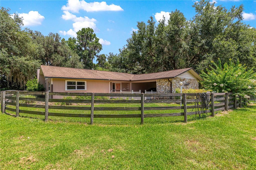 A single-story house with a stone facade and a wooden fence in the front yard — 2645 SW 80TH STREET, OCALA, FL