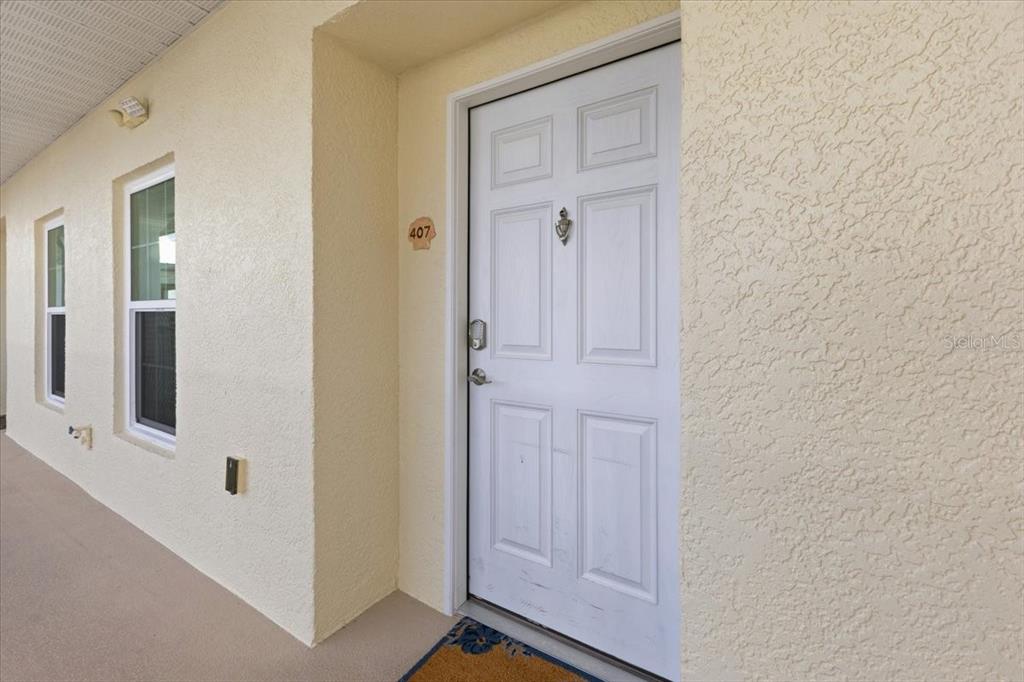 A white front door with a keypad lock and the number 407 on the wall — 8411 PLACIDA ROAD UNIT 407, PLACIDA, FL