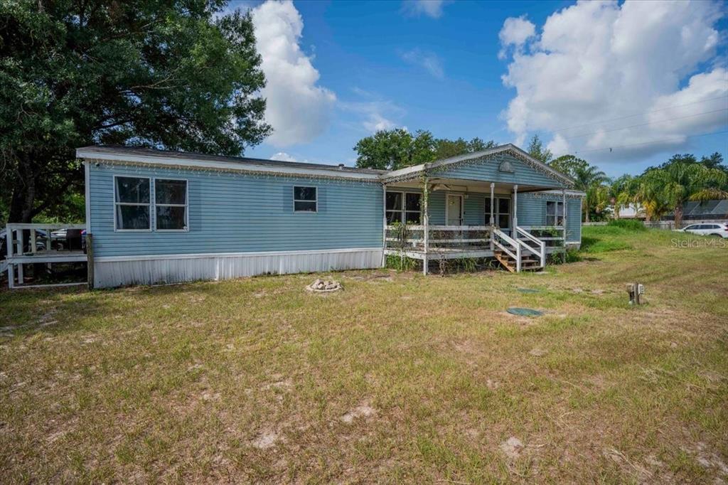 A light blue mobile home with a front porch sits on a grassy lot — 2210 D R BRYANT RD, LAKELAND, FL