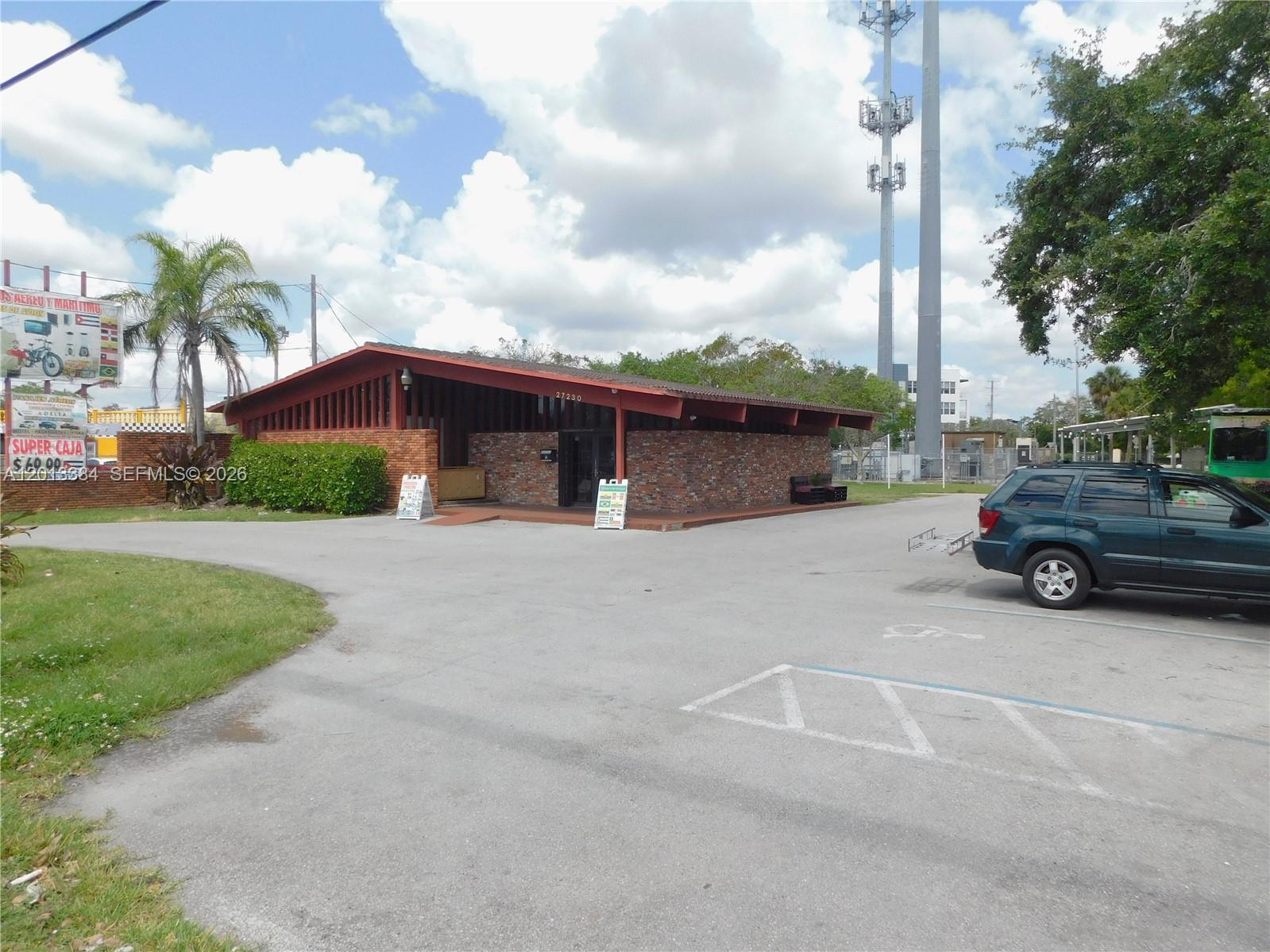 A single-story brick building with a sloped roof sits in a paved parking lot — 27230 S Dixie Hwy, Homestead FL 33032, HOMESTEAD, FL