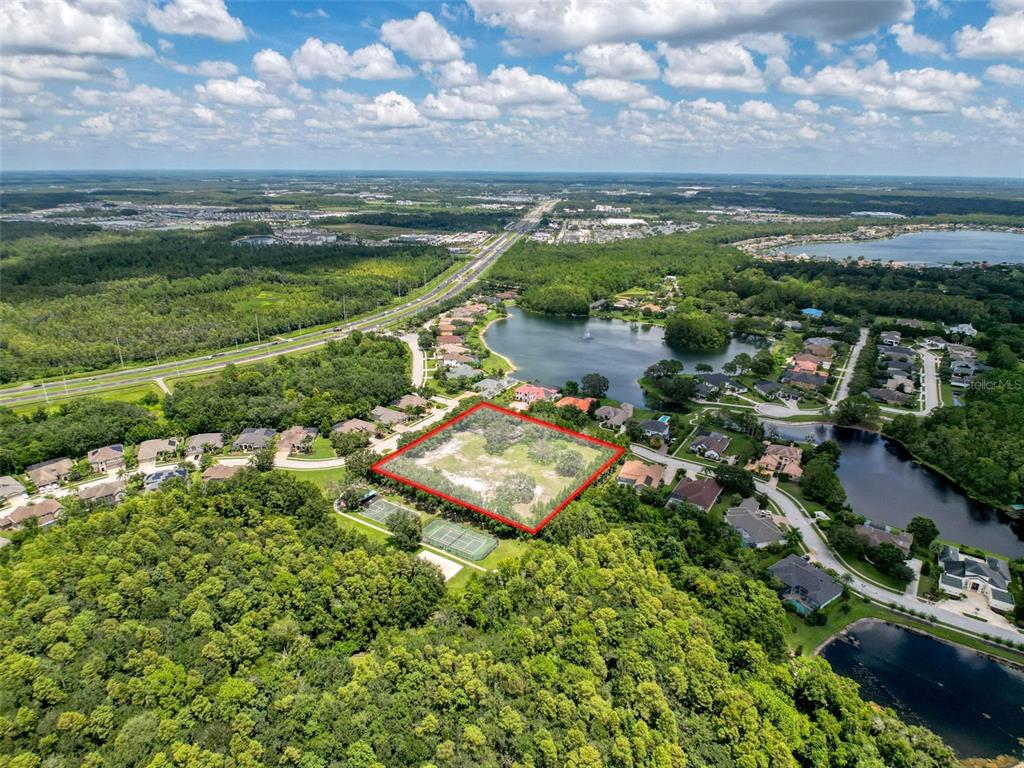 An aerial view shows a vacant, rectangular lot outlined in red within a residential neighborhood — 15438/15440 AZRA DR, ODESSA, FL