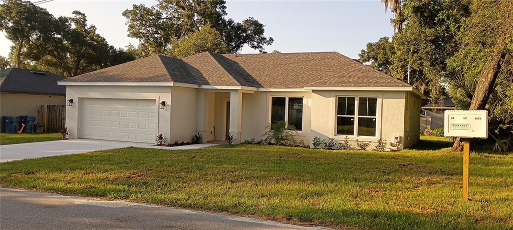 A newly constructed single-story house with a two-car garage and a light-colored stucco exterior — 1176 EIGHTH STREET, ORANGE CITY, FL