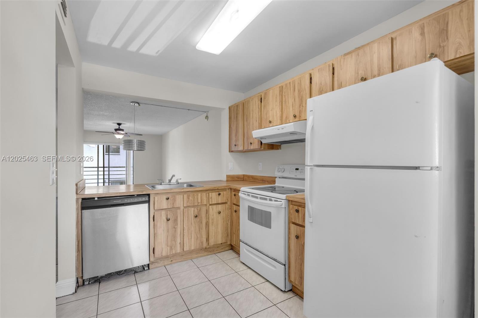 A kitchen features light wood cabinets, white appliances, a stainless steel dishwasher, and tiled flooring — 841 NE 207th Ln # 201, Miami FL 33179, MIAMI, FL