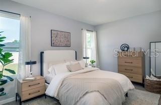 A bedroom features a bed with white bedding, a wooden nightstand, and a wooden dresser — 320 MARION OAKS COURSE, OCALA, FL