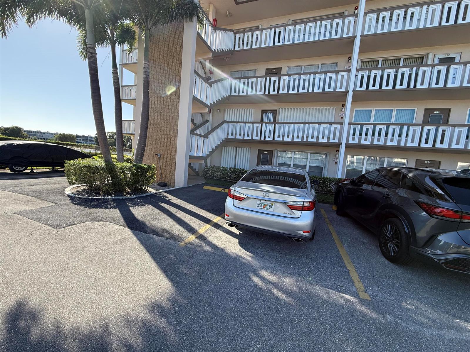 A silver sedan is parked in a lot in front of a three-story apartment building — 313 Greenbrier B, West Palm Beach FL 33417, WEST PALM BEACH, FL