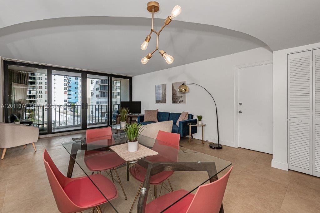 A dining area with a glass table and chairs opens into a living room — 2401 S Ocean Dr # 604, Hollywood FL 33019, HOLLYWOOD, FL