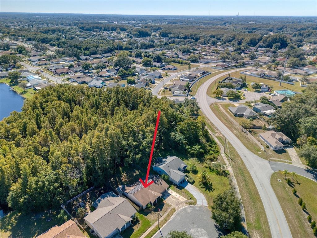 An aerial view shows a suburban house with solar panels on its roof — 8122 MATTHEW DRIVE, NEW PORT RICHEY, FL