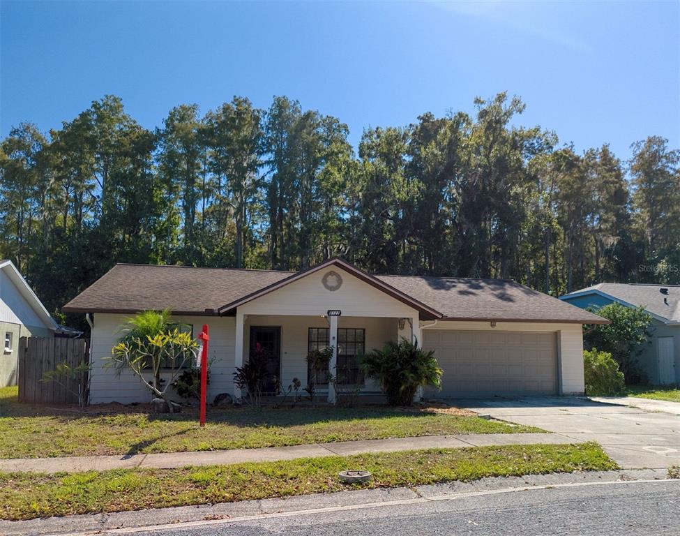 A single-story house with a brown roof, beige siding, and an attached two-car garage — 8122 MATTHEW DRIVE, NEW PORT RICHEY, FL