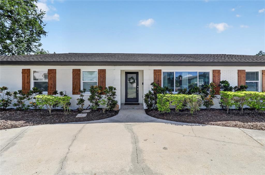 A single-story white brick house with brown shutters and a concrete driveway — 706 S OAKWOOD AVENUE, BRANDON, FL