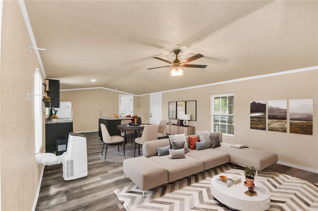 An open-concept living and dining area features light walls, wood-look flooring, and a ceiling fan — 7457 NE HIGHWAY 349, OLD TOWN, FL