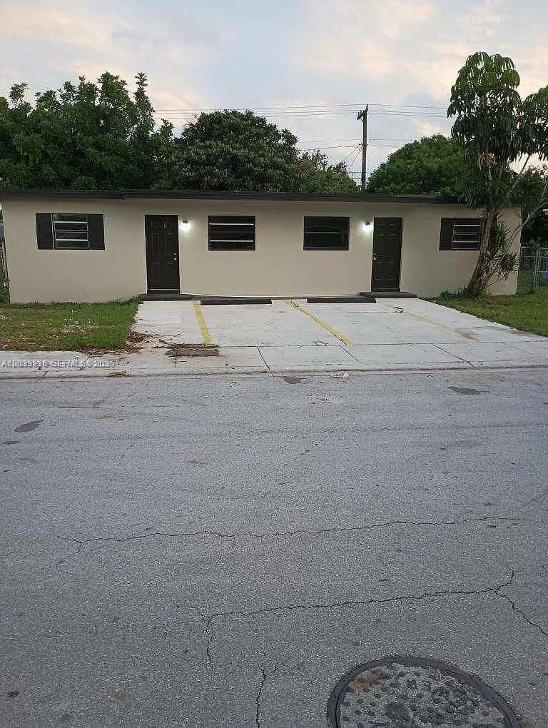 A single-story duplex building features two dark doors and a paved parking area in front — 10540 SW 172nd St, Miami FL 33157, MIAMI, FL