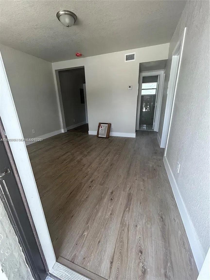 An interior view shows a room with light wood-look flooring and two doorways — 10540 SW 172nd St, Miami FL 33157, MIAMI, FL