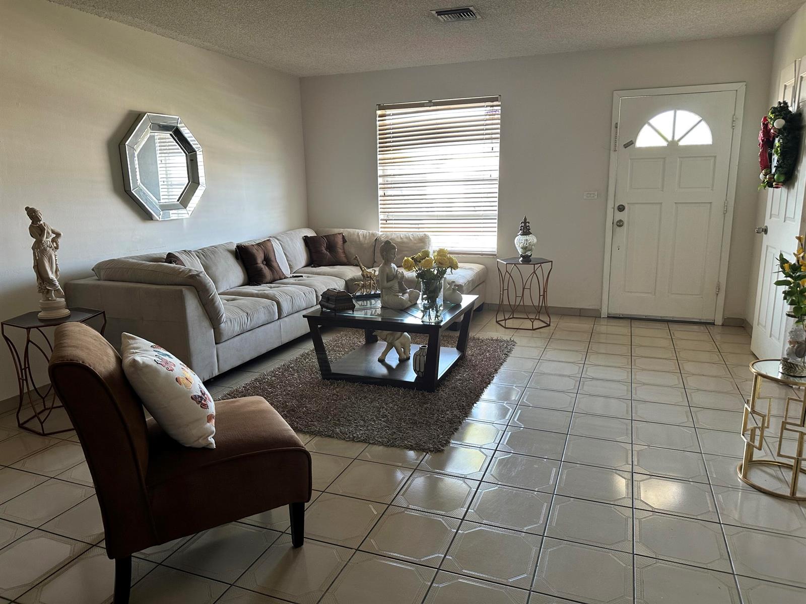 A living room features a beige sectional sofa, a brown armchair, and tile flooring — 7960 NW 174th Street, Hialeah FL 33015, HIALEAH, FL