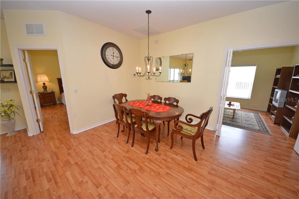 A dining room with wood flooring, a wooden table, chairs, and a chandelier — 4314 BERWICK DRIVE, LAKE WALES, FL