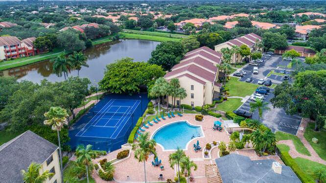 An aerial view shows a community pool, tennis court, apartment buildings, and a small lake — 2311 N Congress Avenue # 28, Boynton Beach FL 33426, BOYNTON BEACH, FL