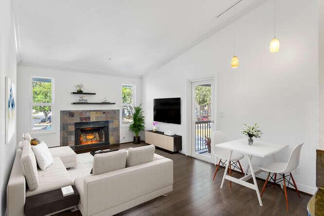 A living room with a stone fireplace, white sofa, and a small dining table — 2311 N Congress Avenue # 28, Boynton Beach FL 33426, BOYNTON BEACH, FL